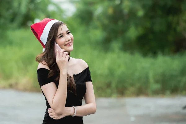 Beautiful Chinese Woman Santa Hat Talking Smart Phone Green Grass — Stock Photo, Image