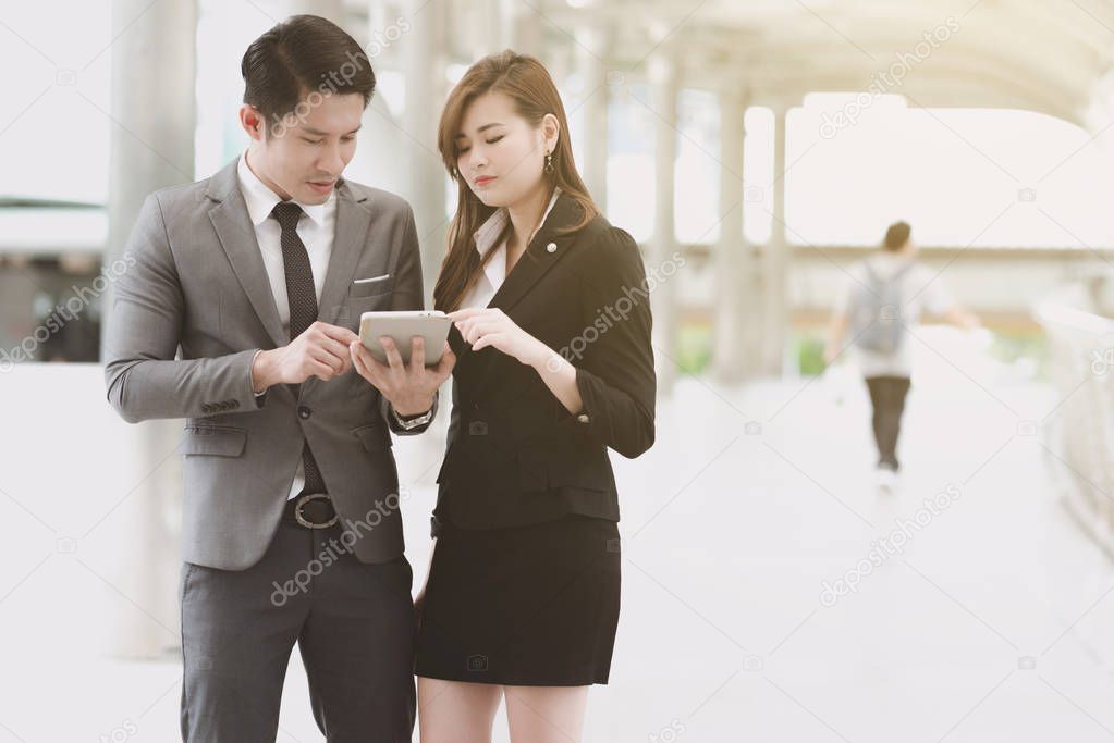 Young generation business team concept. Young business intern woman getting final coach by her male manager before going to meet client in office for the first time. Taking in business district.