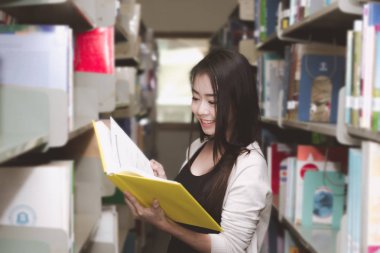 Asya Üniversitesi yaşam kavramı. Her çalışmada Üniversitesi kitaplığındaki kitap arıyorum genç genç kız öğrenci. Gerçek konumda alınan.