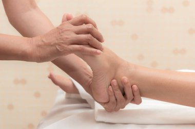 Asya egzotik tatil spa kavramı. Güzel genç beyaz kadın zevk sırasında ayak masajı gerçek spa konumda kapalı alınan Spa'da rahatlatıcı.