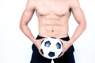 Fitness ve sağlık kavramı. Beyaz arka plan üzerinde izole bir futbol topu tutan spor adam uygun. Kaslı erkek siyah şort giymiş yarı çıplak Asya Çin yalın.