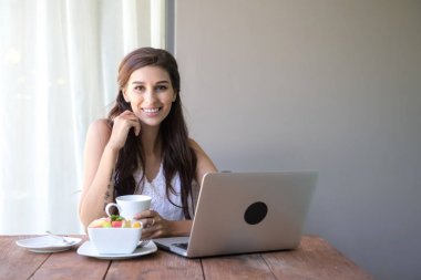 Kahve içer ve dışında çalışan kadın. Dizüstü bilgisayarda onu tatil sırasında bir tropikal çalışan. Beyaz beyaz elbise ile kadın. Çevik. modile ofis kavramı.