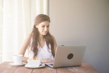 Kahve içer ve dışında çalışan kadın. Dizüstü bilgisayarda onu tatil sırasında bir tropikal çalışan. Beyaz beyaz elbise ile kadın. Çevik. modile ofis kavramı.