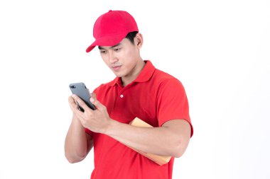 Genç lojistik kariyer kavramı. Mutlu teslim yaptığı telefon müşteri adresi arıyorum. Beyaz arka plan üzerinde izole. Onun erken yirmili kırmızı şapkalı adam kırmızı tişört ve kot Asya Çin uygun.