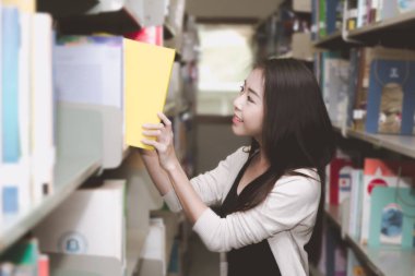Asya Üniversitesi yaşam kavramı. Her çalışmada Üniversitesi kitaplığındaki kitap arıyorum genç genç kız öğrenci. Gerçek konumda alınan.