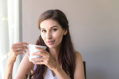 Kahve ve gülümseme sahip bir kadın. Güzel beyaz kadın onu sabah kahve sahip ve çok mutlu görünüyordu gülümseme.