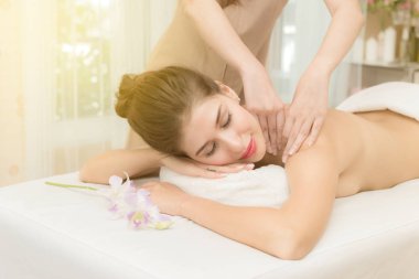 Asian exotic holiday spa concept. Beautiful young white woman enjoy relaxing during massage at spa, taken indoor in real spa location. clipart