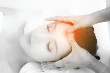 Asya egzotik tatil spa kavramı. Güzel genç Çinli kadın zevk sırasında yüz masaj gerçek spa konumda kapalı alınan Spa'da rahatlatıcı. Üstten Görünüm.