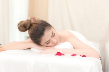 Asya egzotik tatil spa kavramı. Güzel genç Çinli kadın zevk gerçek spa konumda kapalı alınan Spa'da masaj sırasında rahatlatıcı.