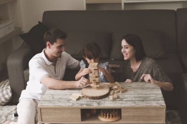 Annem ve babam oynamak puzzle oyunu oturma odasında kendi kızı ile birlikte. Aile eğlenceli zaman kavramı.