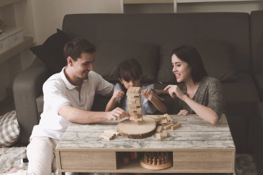 Annem ve babam oynamak puzzle oyunu oturma odasında kendi kızı ile birlikte. Aile eğlenceli zaman kavramı.