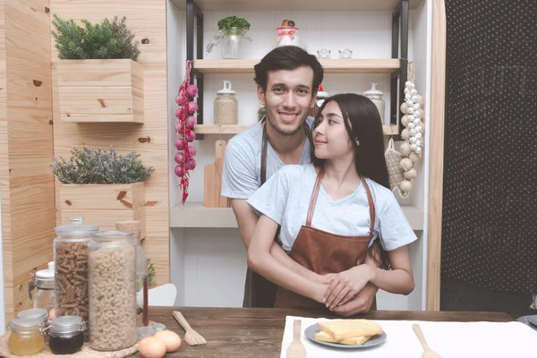 Genç adam mutfakta birbirlerine sarılma Çinli kız arkadaşıyla beyaz. Marrige kavramı önce birlikte yaşayan genç Çift.