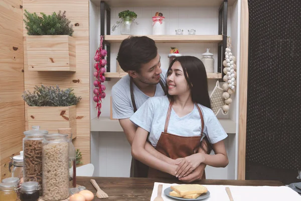 Genç adam mutfakta birbirlerine sarılma Çinli kız arkadaşıyla beyaz. Marrige kavramı önce birlikte yaşayan genç Çift.