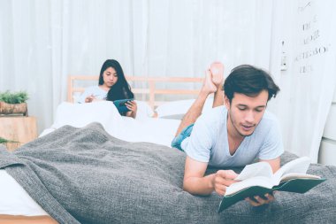 Karışık yarış severler kavramı. Katılmak için genç ve güzel Çinli kız arkadaşıyla gönüllülük a kitap onun yatak odasında genç beyaz erkek. Giyiyor mavi jeans, mavi gömlek ve erken yirmili. Kapalı alınan.