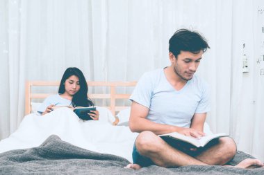Karışık yarış severler kavramı. Katılmak için genç ve güzel Çinli kız arkadaşıyla gönüllülük a kitap onun yatak odasında genç beyaz erkek. Giyiyor mavi jeans, mavi gömlek ve erken yirmili. Kapalı alınan.