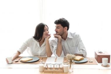 Karışık yarış modern ebeveynlik kavramı. Genç ile birlikte brekfast masada oturan beyaz erkek ve hamile Çinli kadın yarış çift karışık gülümseyen