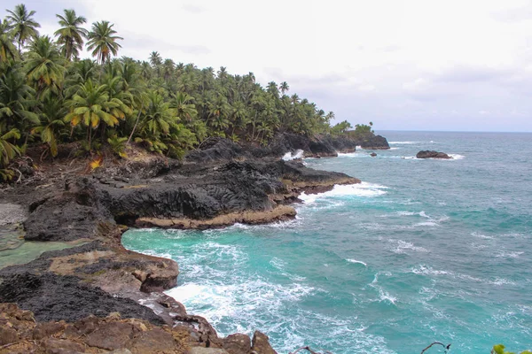 Bela praia com rochas vulcânicas e água limpa em São Tomé — Fotografia de Stock