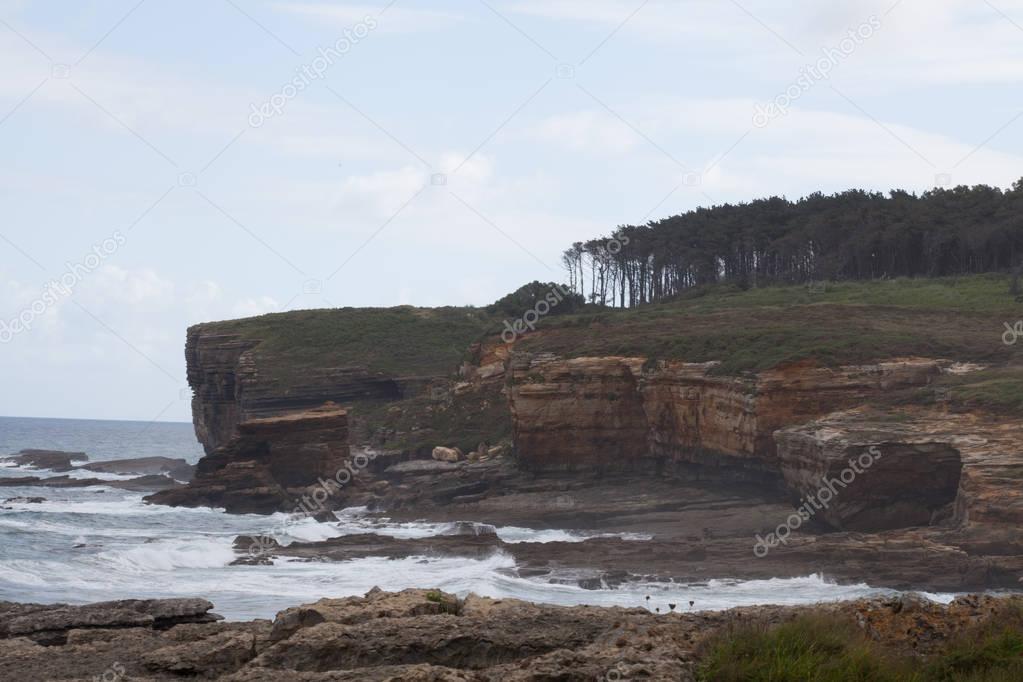 Coast landscape. Cliff and surf at coast line.