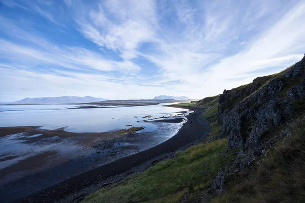 Landscape with cliff and mountain range at the ocean. Light refl — Stock Photo, Image