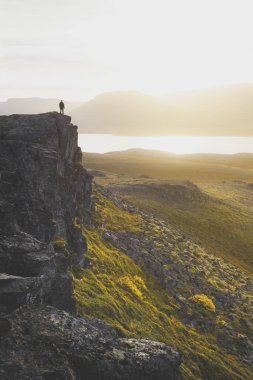 Fiyatı bir kayalık uçurum gün batımı sırasında üzerinde. Harika atmosfer 