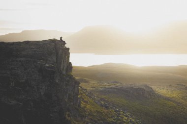 Fiyatı bir kayalık uçurum gün batımı sırasında üzerinde. Harika atmosfer 