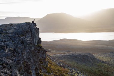 Fiyatı bir kayalık uçurum gün batımı sırasında üzerinde. Harika atmosfer 