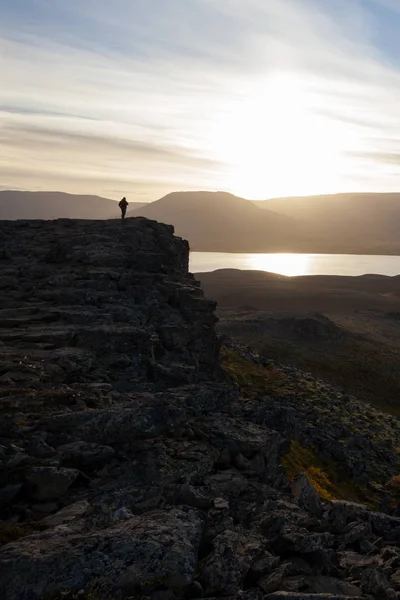 Hiker on a rocky cliff during the sunset. Great atmosphere with