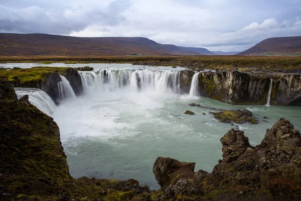 Kallt vatten i Island. Vattenfallet Goðafoss i klippiga bergen. Fr — Stockfoto