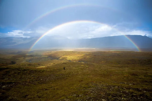 Mooie regenboog in de vallei tussen de bergen. Riviertje — Stockfoto