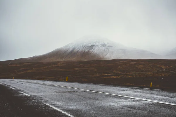 Empty road in front of a mountain range with fog. Lovely landsca Stock Picture