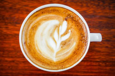 Ahşap masadaki Latte Kahve Sanatı .