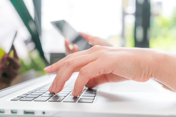 Primer plano de la mujer de negocios escribiendo a mano en el teclado del ordenador portátil con mo —  Fotos de Stock