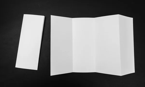 Four - fold white template paper on black background . — Stock Photo, Image