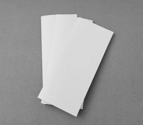 Dreifach weißes Schablonenpapier auf grauem Hintergrund . — Stockfoto