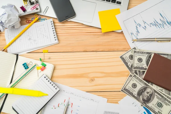 Finansiella diagram på bordet med laptop, telefon, dollar bankn — Stockfoto