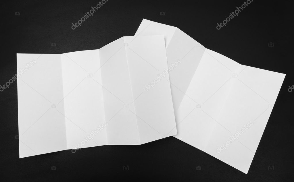 Four - fold white template paper on black background .