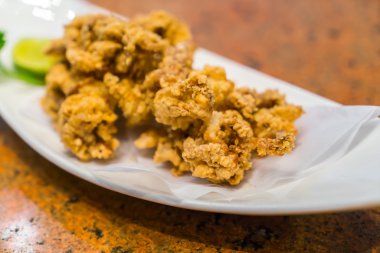 Beyaz tabakta kızarmış mürekkep balığı. .