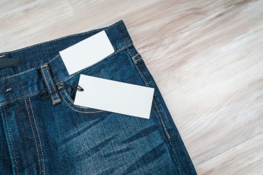 Mavi jeans ahşap arka plan üzerinde fiyat etiketi ile .