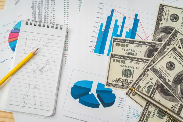 Финансовые диаграммы на столе с банкнотами долларов  . — стоковое фото