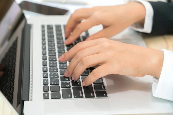 Primer plano de la mujer de negocios escribiendo a mano en el teclado del ordenador portátil . — Foto de Stock