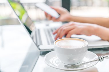 Closeup Latte Kahve sanat ve kadın el laptop keya yazma