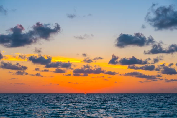Hermosa puesta de sol con el cielo sobre el mar tranquilo en las Maldivas tropicales es —  Fotos de Stock