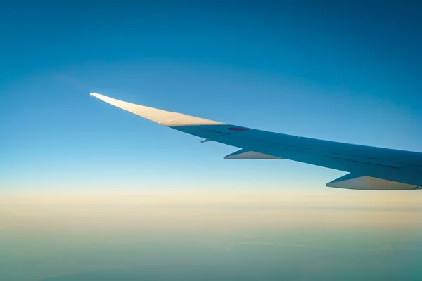 Ala de un avión volando sobre las nubes —  Fotos de Stock