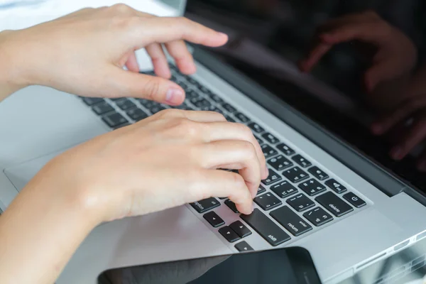 Mão de mulher de negócios com gráficos financeiros e laptop na mesa — Fotografia de Stock