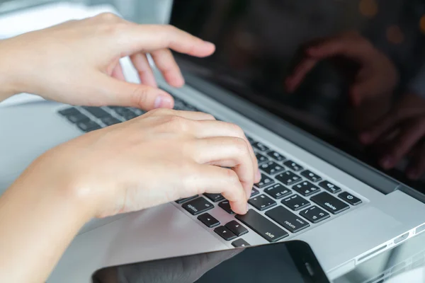 Mão de mulher de negócios com gráficos financeiros e laptop na mesa — Fotografia de Stock