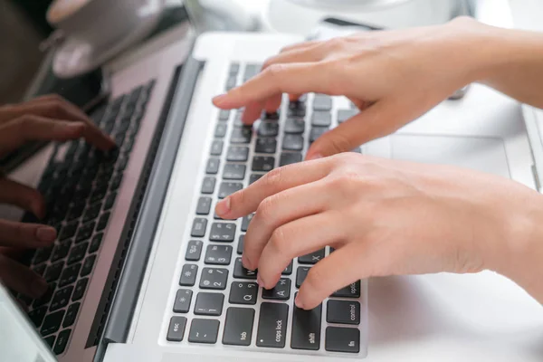 Primo piano della mano della donna d'affari che digita sulla tastiera del computer portatile . — Foto Stock