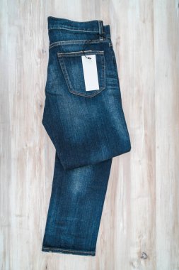 Mavi jeans ahşap arka plan üzerinde fiyat etiketi ile .