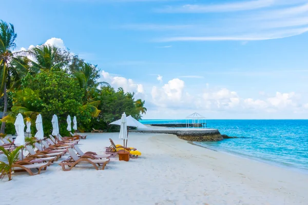 Liegestühle mit Sonnenschirm auf Malediven-Insel mit weißem Sand — Stockfoto