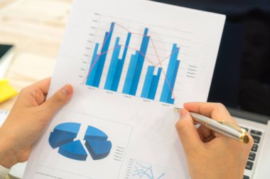 Kapalı toplantıda laptop ve mali grafikleri kullanarak iş adamları