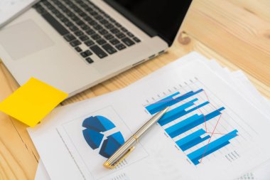 Dizüstü bilgisayar ile masada mali çizelgeleri .